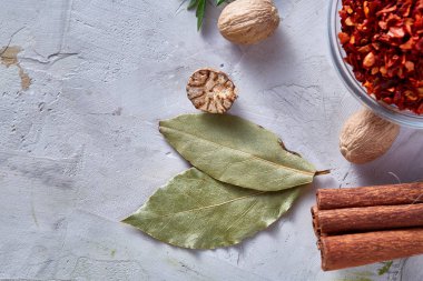 Defne yaprağı, küçük Hindistan cevizi ve tarçın beyaz dokulu arka plan, üstten görünüm, yakın çekim, seçici odak.