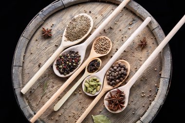 Renkli aromatik yemek eski ahşap varil, yakın çekim, düz için çeşitli baharatlar yatıyordu, seçici odak.