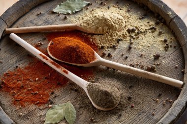 Paprica, kara biber tam bir üç tahta kaşıklar görünümünü top, ahşap varil arka planda, seçici odak köri.