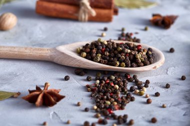 Kırpma yolu üzerinde beyaz tahta kaşıkla peppercorns dokulu arka plan, yakın çekim, seçici odak.