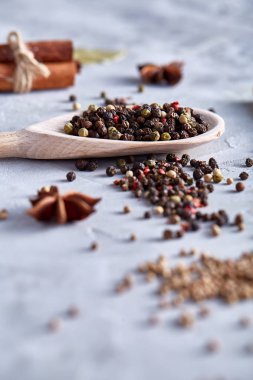 Kırpma yolu üzerinde beyaz tahta kaşıkla peppercorns dokulu arka plan, yakın çekim, sığ derinlik-in tarla.