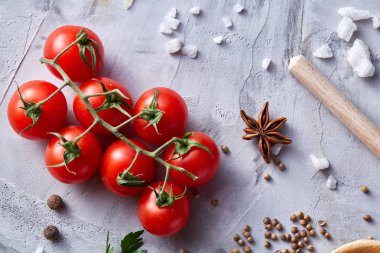 Kiraz domates ve çeşitli baharatlar beyaz dokulu arka plan, düz üzerinde yatıyordu, yakın çekim, seçici odak.