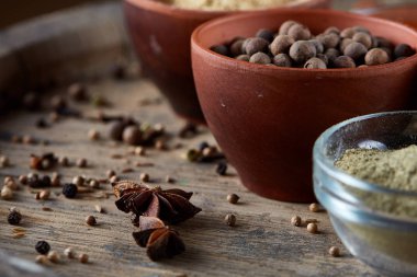 Seramik kaseler üst kısmında ahşap varil, yakın çekim, seçici odak, sığ derinlik-in tarla içinde baharatlar.