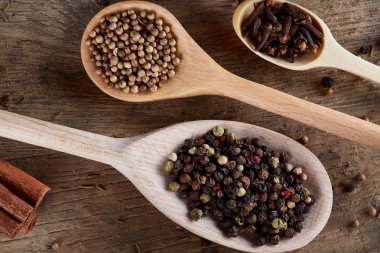 Aromatik eski ahşap masa, yakın çekim, düz üstünde tahta kaşık toz içinde yemek pişirmek için çeşitli baharatlar yatıyordu, sığ derinlik-in tarla.