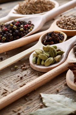 Renkli aromatik eski ahşap masa, yakın çekim, düz yemek pişirmek için çeşitli baharatlar lay, seçici odak, dikey.