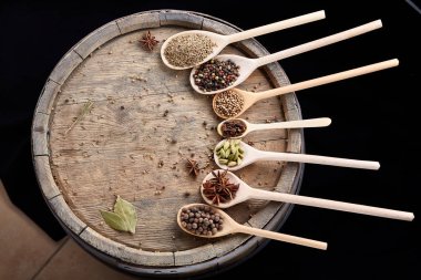 Renkli aromatik yemek eski ahşap varil, yakın çekim, düz için çeşitli baharatlar yatıyordu, seçici odak.