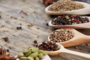 Aromatik kaşıklarla eski ahşap masa, yakın çekim, düz yemek pişirmek için çeşitli baharatlar yatıyordu, seçici odak.