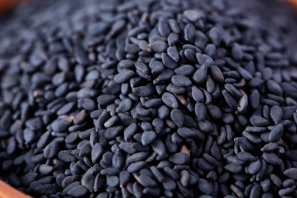 Black sesame seed background and textured, close-up, macro, shallow depth of field.