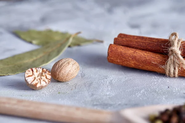 Hoja de laurel, nuez moscada y canela sobre fondo blanco texturizado, vista superior, primer plano, enfoque selectivo . —  Fotos de Stock