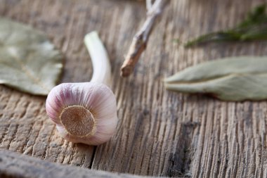 Organik defne yaprağı ve ahşap masa, üstten görünüm, yakın çekim, seçici odak sarımsak.