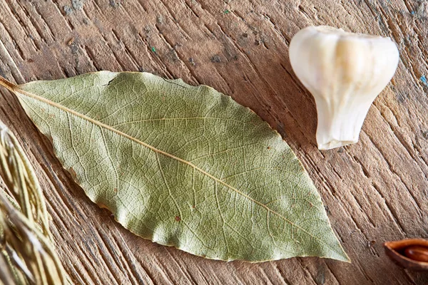 Organik defne yaprağı ve ahşap masa, üstten görünüm, yakın çekim, seçici odak sarımsak.