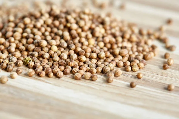 Kişniş tohumu yığın üzerine sığ derinlik-in tarla açık ahşap renkli, yakın çekim, makro.