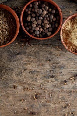 Ahşap varil, yakın çekim, seçici odak, dikey üst Seramik kase içinde baharatlar.