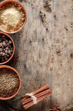 Ahşap varil, yakın çekim, seçici odak, dikey üst Seramik kase içinde baharatlar.