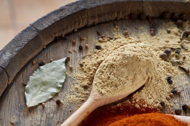 Paprica ve karabiber dolu bir tahta kaşıklar üstten görünüm ahşap varil arka plan, seçici odak üzerinde.