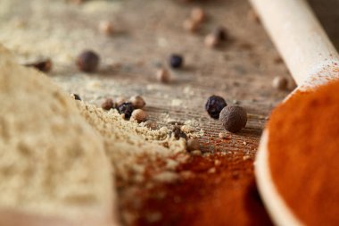 Tahta kaşık ve kase ve biraz tuz bir eski ahşap varil, üstten görünüm, yakın çekim, seçici odak içinde çeşitli baharatlar.