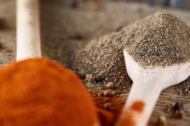 Tahta kaşık ve kase ve biraz tuz bir eski ahşap varil, üstten görünüm, yakın çekim, seçici odak içinde çeşitli baharatlar.