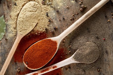 Tahta kaşık ve kase ve biraz tuz bir eski ahşap varil, üstten görünüm, yakın çekim, seçici odak içinde çeşitli baharatlar.