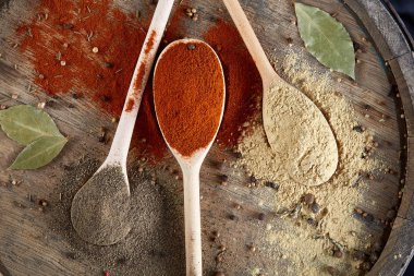 Tahta kaşık ve kase ve biraz tuz bir eski ahşap varil, üstten görünüm, yakın çekim, seçici odak içinde çeşitli baharatlar.