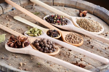 Aromatik kaşıklarla eski ahşap masa, yakın çekim, düz yemek pişirmek için çeşitli baharatlar yatıyordu, seçici odak.