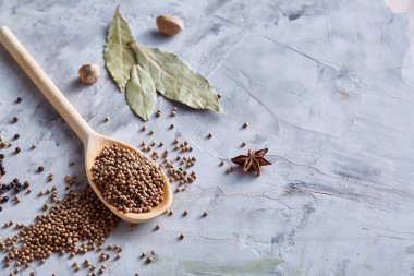 Kırpma yolu üzerinde beyaz tahta kaşıkla kişniş dokulu arka plan, yakın çekim, seçici odak.