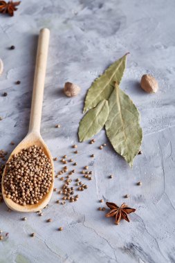 Kırpma yolu üzerinde beyaz tahta kaşıkla kişniş dokulu arka plan, yakın çekim, seçici odak.