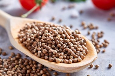 Kırpma yolu üzerinde beyaz tahta kaşıkla kişniş dokulu arka plan, yakın çekim, seçici odak.