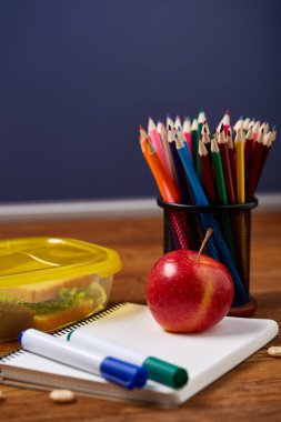 Beyaz masa, seçici odak sağlıklı öğle yemeği kutusu ve okul malzemeleri ile okul öğle yemeği molası kavramı.