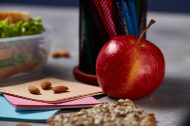 Beyaz masa, seçici odak sağlıklı öğle yemeği kutusu ve okul malzemeleri ile okul öğle yemeği molası kavramı.