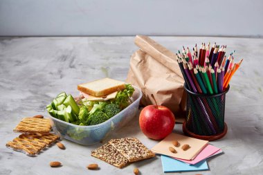 Okul veya sandviç ile öğle yemeği kutusu ve çeşitli renkli sebze ve meyve ahşap arka plan üzerinde piknik, yakın çekim.