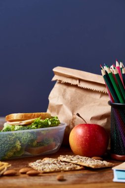 Beyaz masa, seçici odak sağlıklı öğle yemeği kutusu ve okul malzemeleri ile okul öğle yemeği molası kavramı.