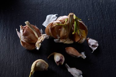 Sarımsak parçaları koyu siyah arka plan üzerine sığ derinliği alan, seçici odak, makro yakın çekim