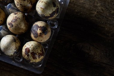 Seçici odak eski ahşap panoları, boşluk, arka plan üzerinde benekli bıldırcın yumurtası düzenlenmiş.