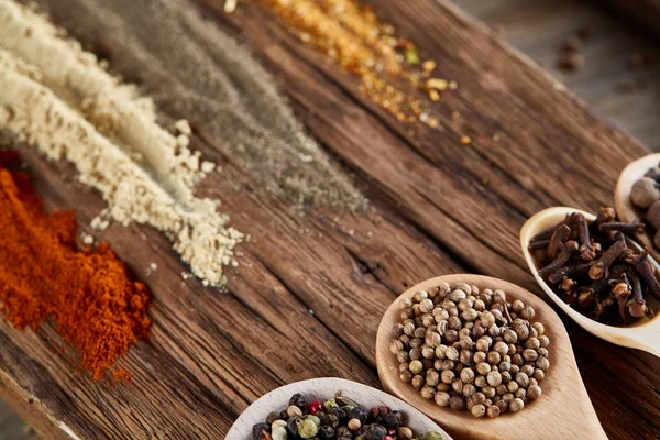 Row of wooden spoons with spices on vintage background, diminishing perspective, close-up, selective focus — Stock Photo, Image