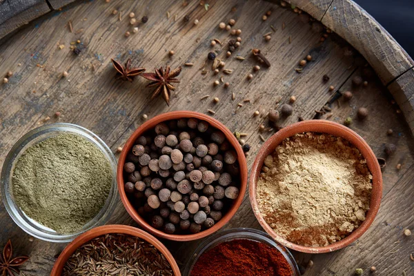 Ahşap varil, yakın çekim, seçici odak, dikey üst Seramik kase içinde baharatlar.