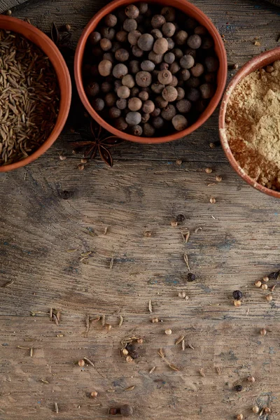 Ahşap varil, yakın çekim, seçici odak, dikey üst Seramik kase içinde baharatlar.