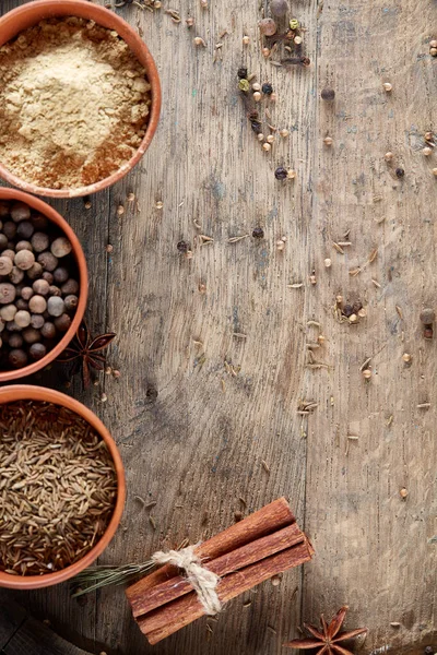 Ahşap varil, yakın çekim, seçici odak, dikey üst Seramik kase içinde baharatlar.