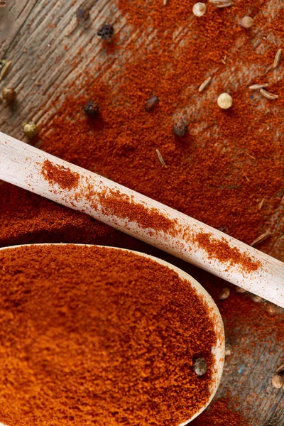 Paprica ve karabiber dolu bir tahta kaşıklar üstten görünüm ahşap varil arka plan, seçici odak üzerinde.