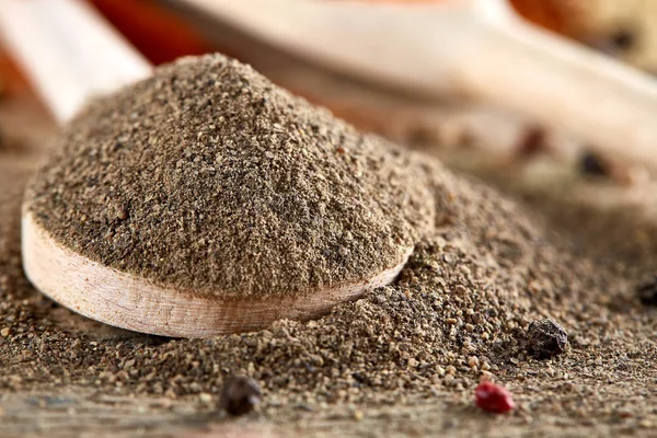 Paprica ve karabiber dolu bir tahta kaşıklar üstten görünüm ahşap varil arka plan, seçici odak üzerinde.