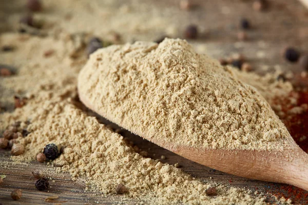 Paprica ve karabiber dolu bir tahta kaşıklar üstten görünüm ahşap varil arka plan, seçici odak üzerinde.