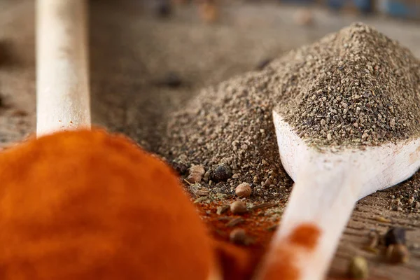 Tahta kaşık ve kase ve biraz tuz bir eski ahşap varil, üstten görünüm, yakın çekim, seçici odak içinde çeşitli baharatlar.