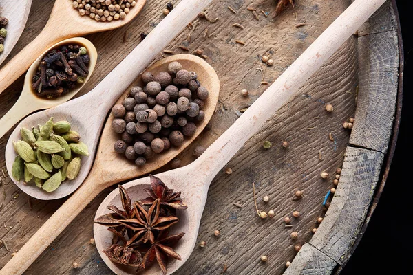 Aromatik kaşıklarla eski ahşap masa, yakın çekim, düz yemek pişirmek için çeşitli baharatlar yatıyordu, seçici odak.
