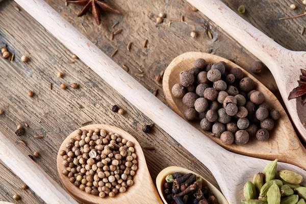 Aromatik kaşıklarla eski ahşap masa, yakın çekim, düz yemek pişirmek için çeşitli baharatlar yatıyordu, seçici odak.