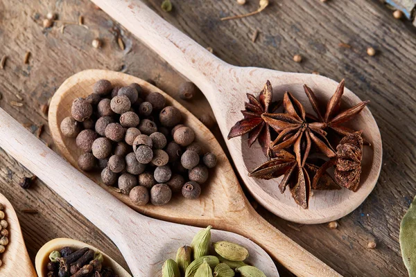 Aromatik kaşıklarla eski ahşap masa, yakın çekim, düz yemek pişirmek için çeşitli baharatlar yatıyordu, seçici odak.