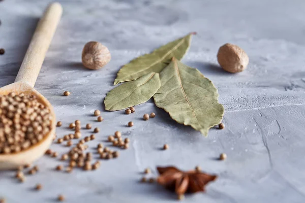 Kırpma yolu üzerinde beyaz tahta kaşıkla kişniş dokulu arka plan, yakın çekim, seçici odak.