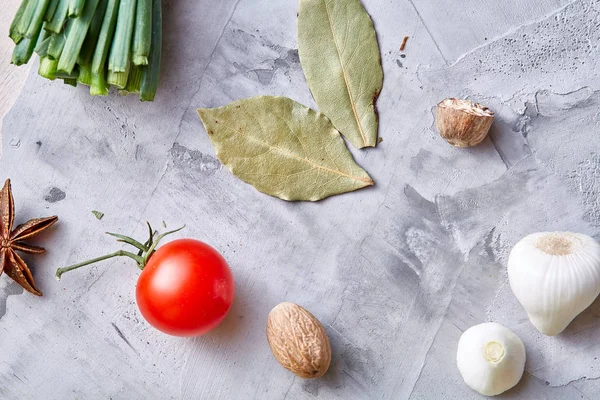 Kiraz domates ve çeşitli baharatlar beyaz dokulu arka plan, düz üzerinde yatıyordu, yakın çekim, seçici odak.