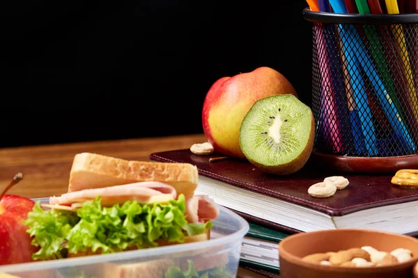 Okul veya sandviç ile öğle yemeği kutusu ve çeşitli renkli sebze ve meyve ahşap arka plan üzerinde piknik, yakın çekim.