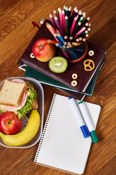 Un taccuino, due pennarelli e un assortimento di biscotti su un tavolo di legno, spazio per copiare il testo, messa a fuoco selettiva . — Foto Stock