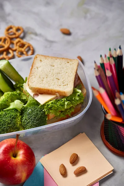 Okul veya sandviç ile öğle yemeği kutusu ve çeşitli renkli sebze ve meyve ahşap arka plan üzerinde piknik, yakın çekim.