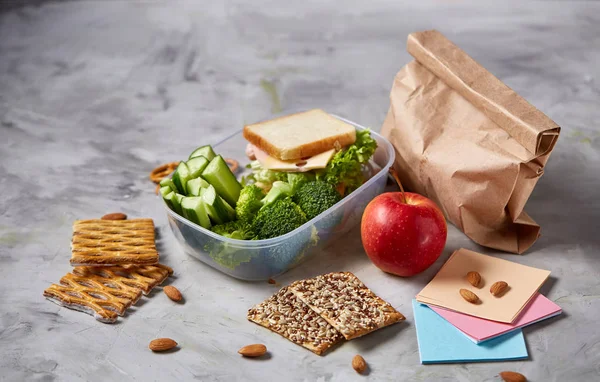 Okul veya sandviç ile öğle yemeği kutusu ve çeşitli renkli sebze ve meyve ahşap arka plan üzerinde piknik, yakın çekim.